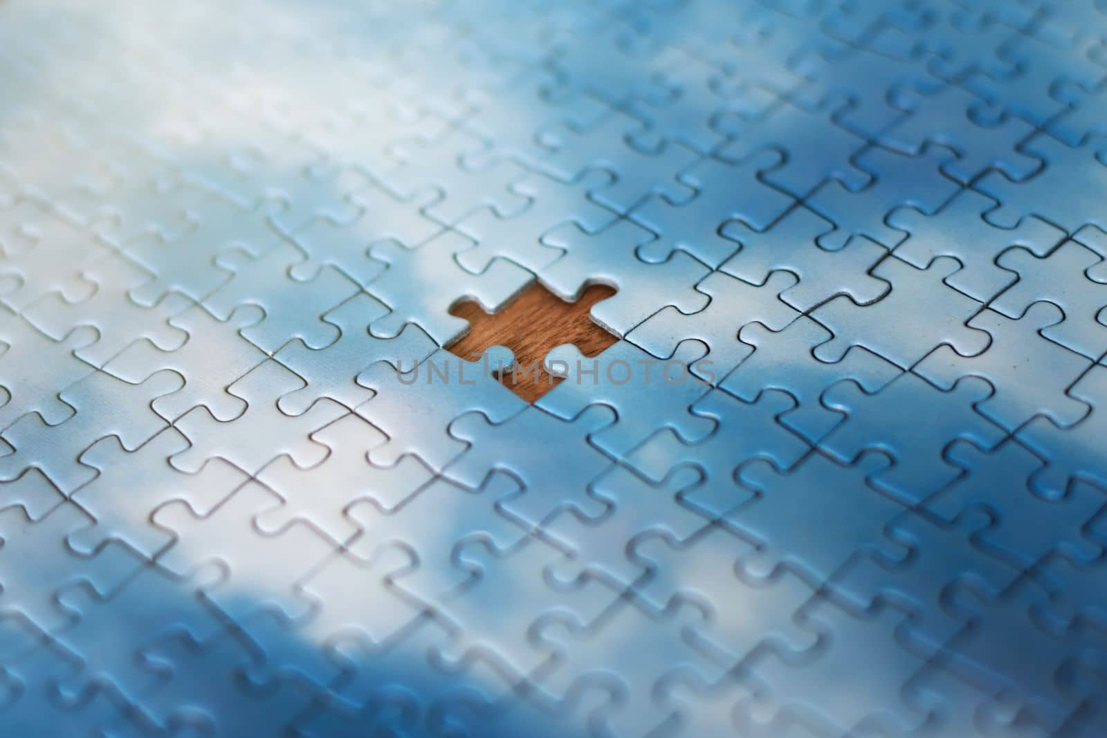 The missing piece of the sky puzzle, the concept of completing a big job, the final of the project, the successful solution of business problems. The hand puts the last piece of the jigsaw