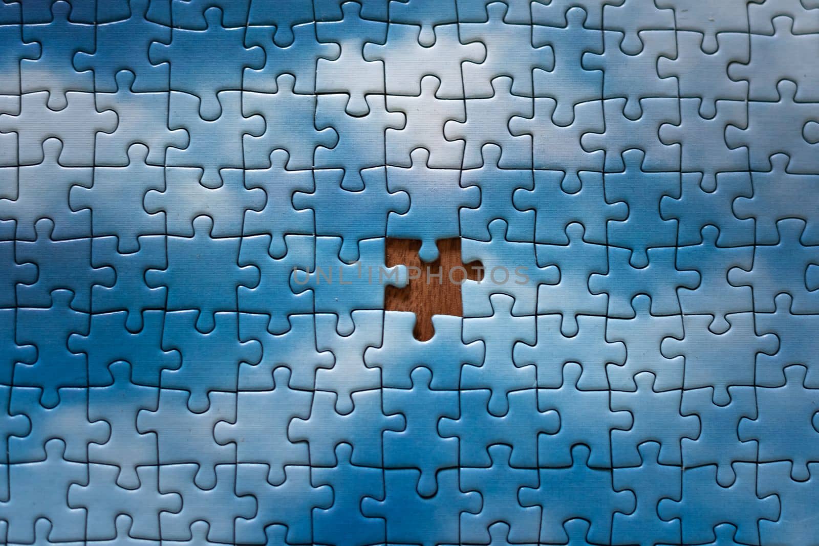 The missing piece of the sky puzzle, the concept of completing a big job, the final of the project, the successful solution of business problems. The hand puts the last piece of the jigsaw