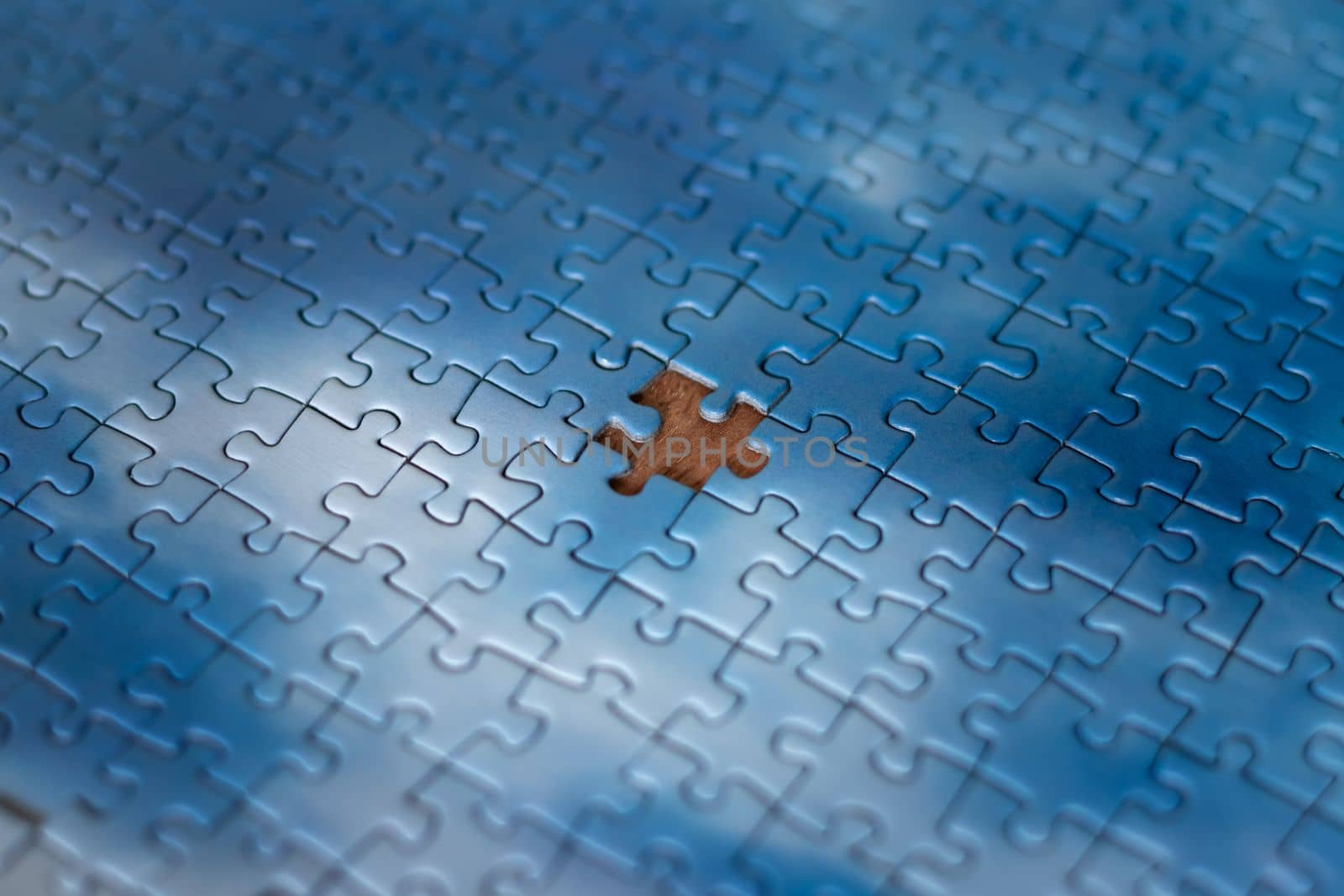 The missing piece of the sky puzzle, the concept of completing a big job, the final of the project, the successful solution of business problems. The hand puts the last piece of the jigsaw