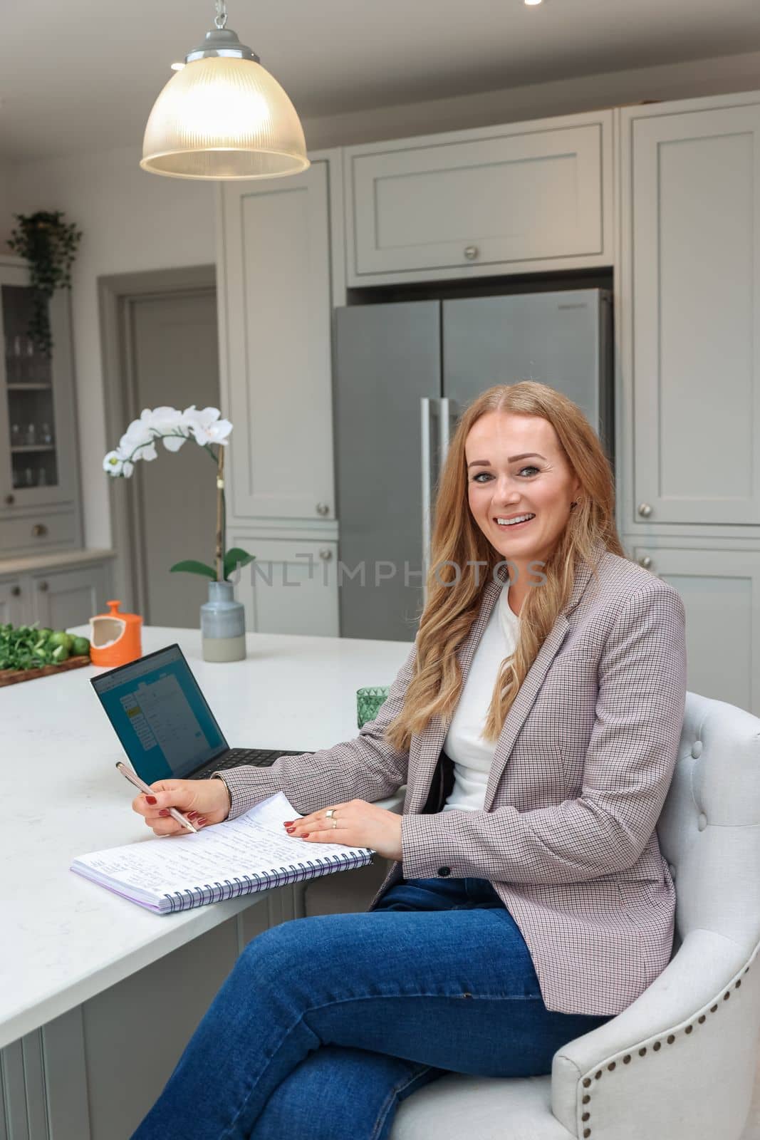 Remote Work. Beautiful middle age Freelancer Lady Working With Laptop In Kitchen, Happy Woman Using Computer At Home, Sitting At Table In Cozy Interior, Enjoying Online Job, Free Space