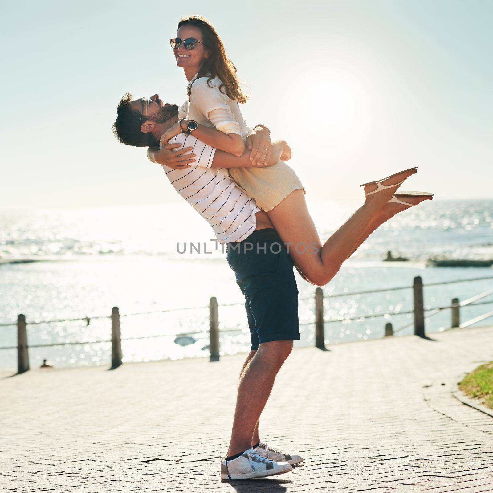 Summer romance goals. Full length shot of a happy young couple embracing on a summers day outdoors. by YuriArcurs