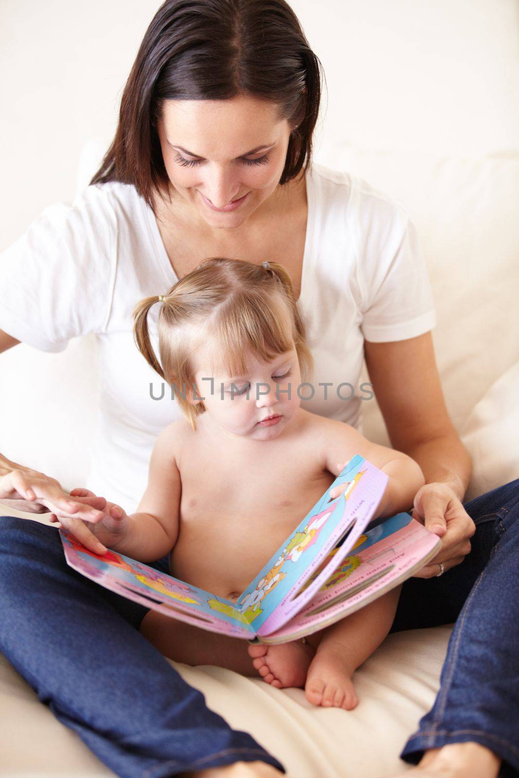 Deciding on a story. A cute little girl reading with her mother