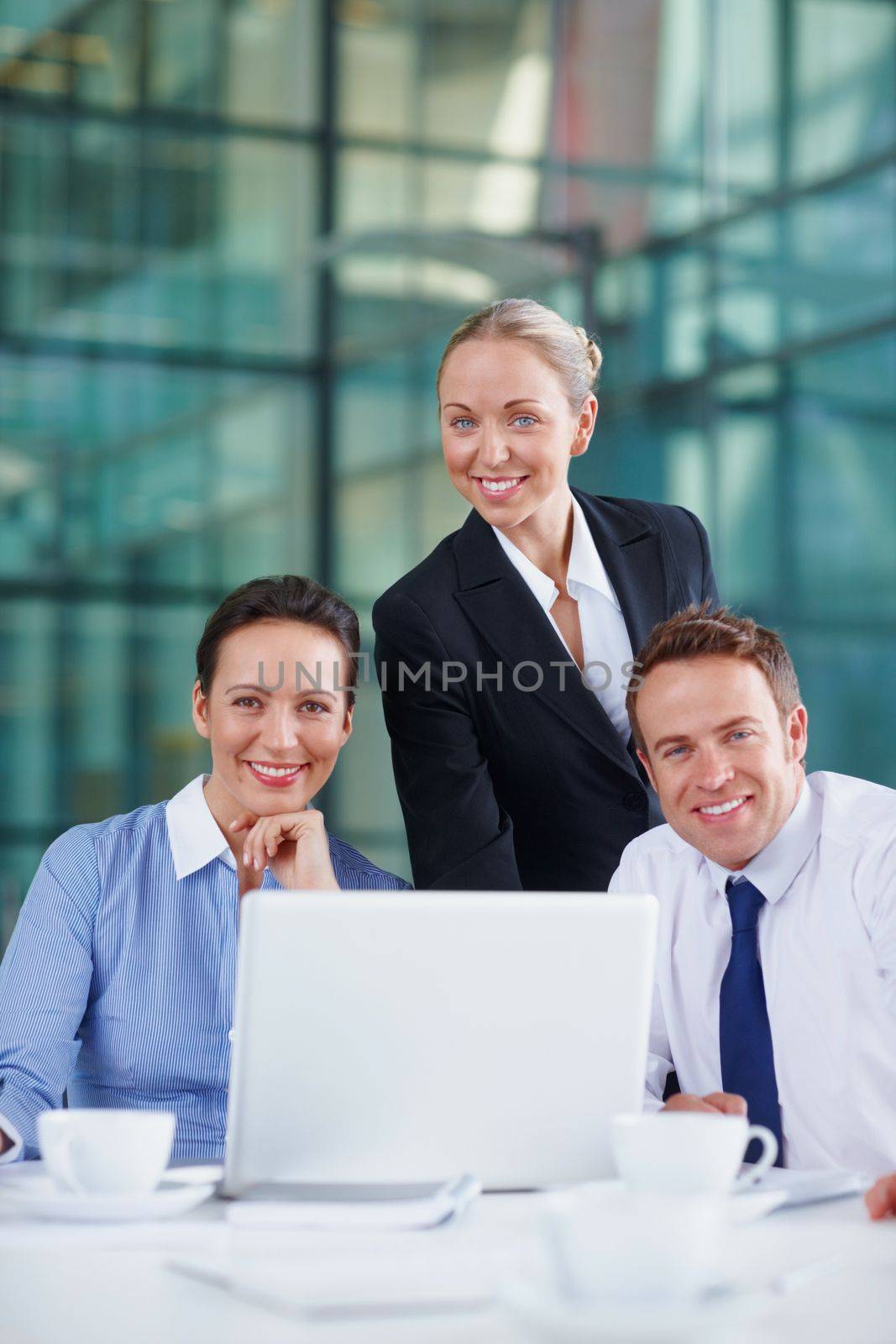 Confident business team. Confident business people smiling with laptop coffee cups on table