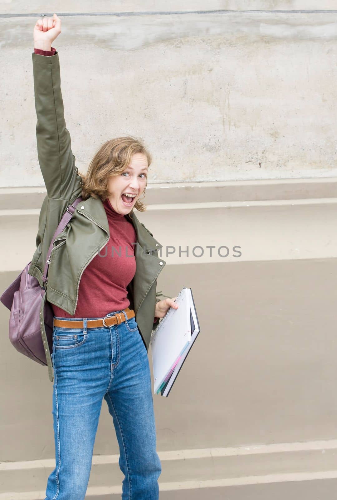 young student girl jumps and gesticulates expressing joy about passing the exam, bright emotions, High quality photo