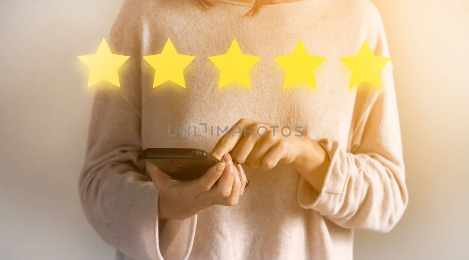 A young girl votes, puts a five-star rating in the reviews for the purchase, for the received, purchased services. Woman holding a phone in her hands close-up, sending a positive feedback.