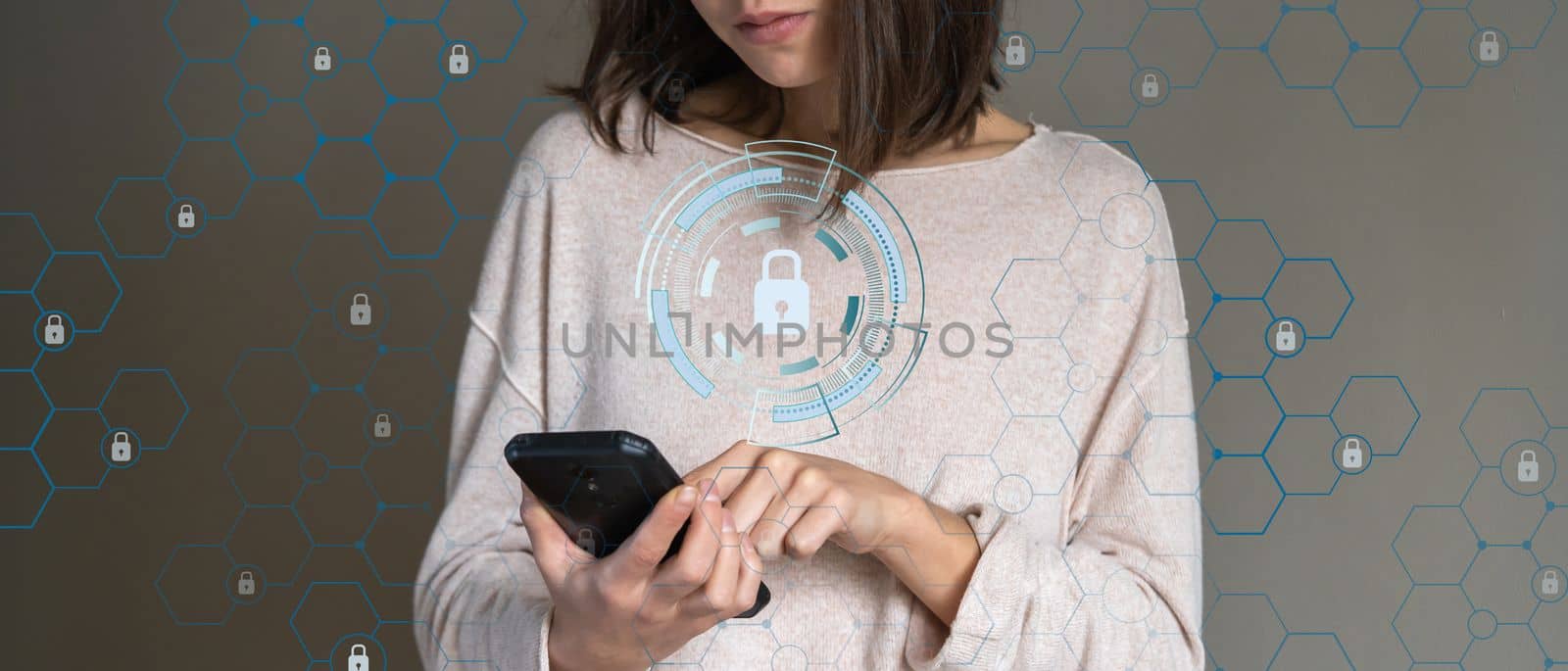 Young girl holds a mobile phone in her hands, swipes her finger across the screen, a concept on the topic of profile and data security in a mobile device, a woman uses an application on a smartphone.