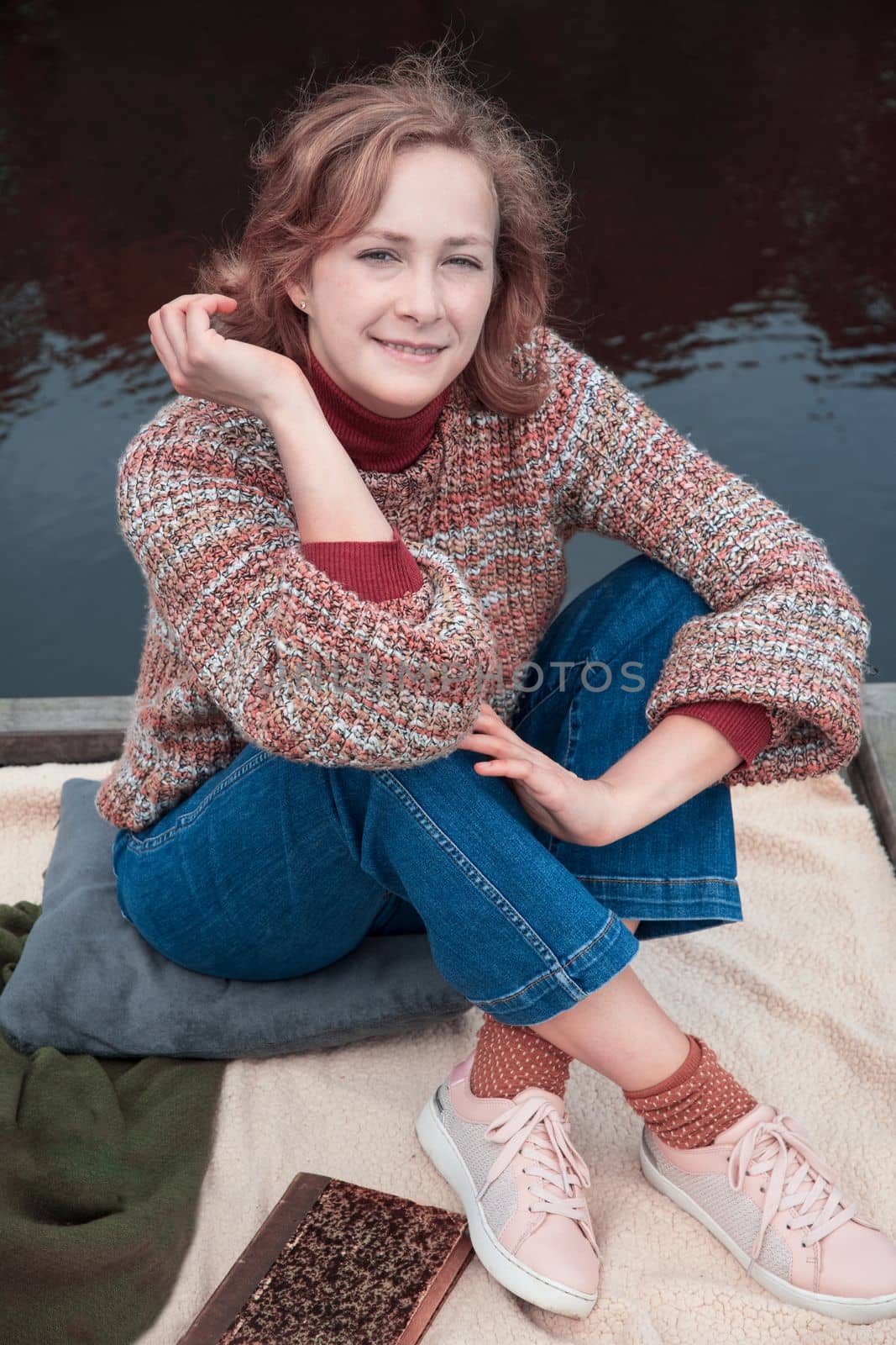 portrait of a young beautiful girl with developing hair in an autumn sweater. High quality photo