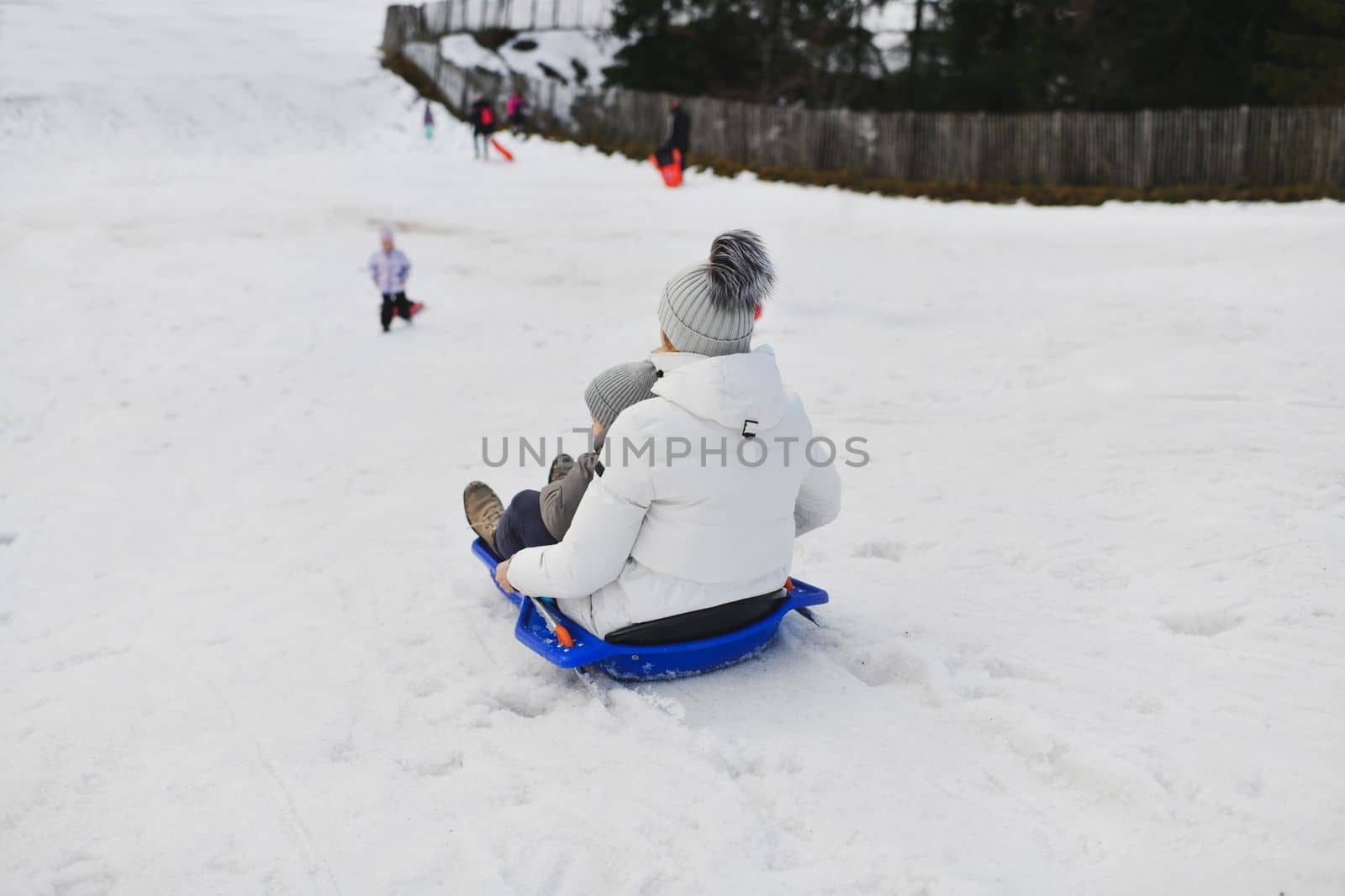 The mother with child sledding in the snow