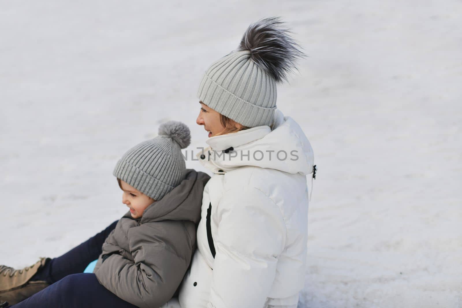 The mother with child sledding in the snow