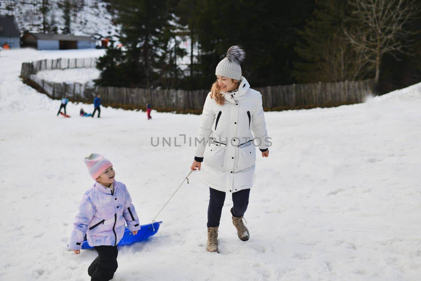 The mother with child sledding in the snow