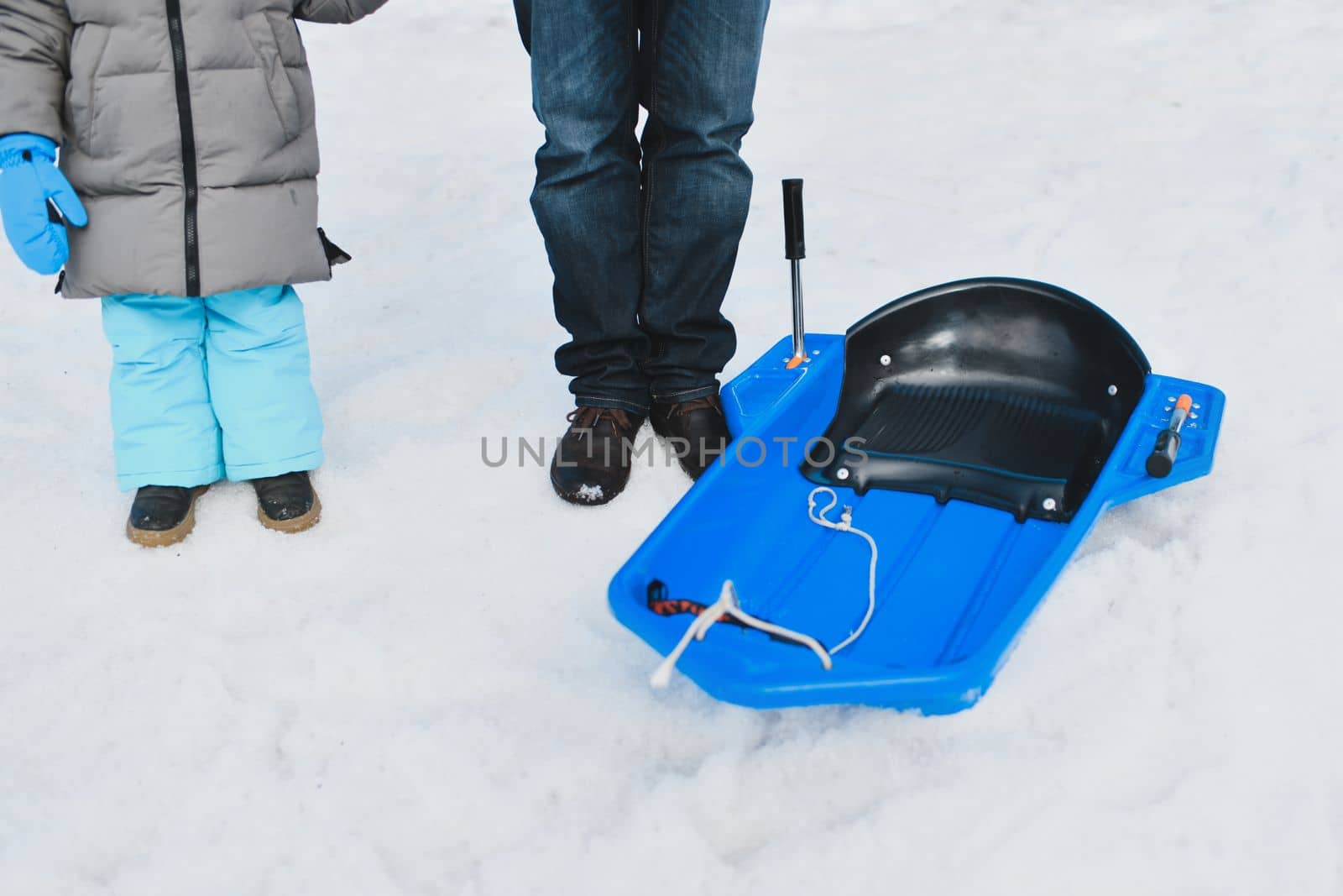 The father with child sledding in the snow