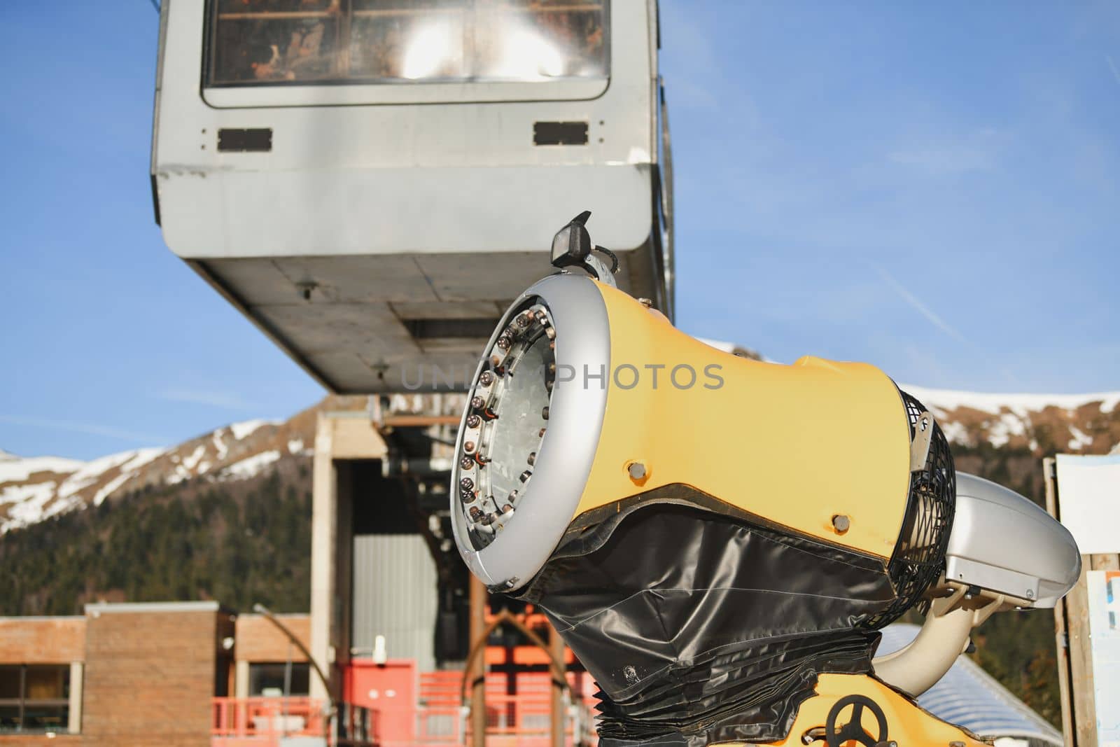 Snow gun in the mountains and cable car
