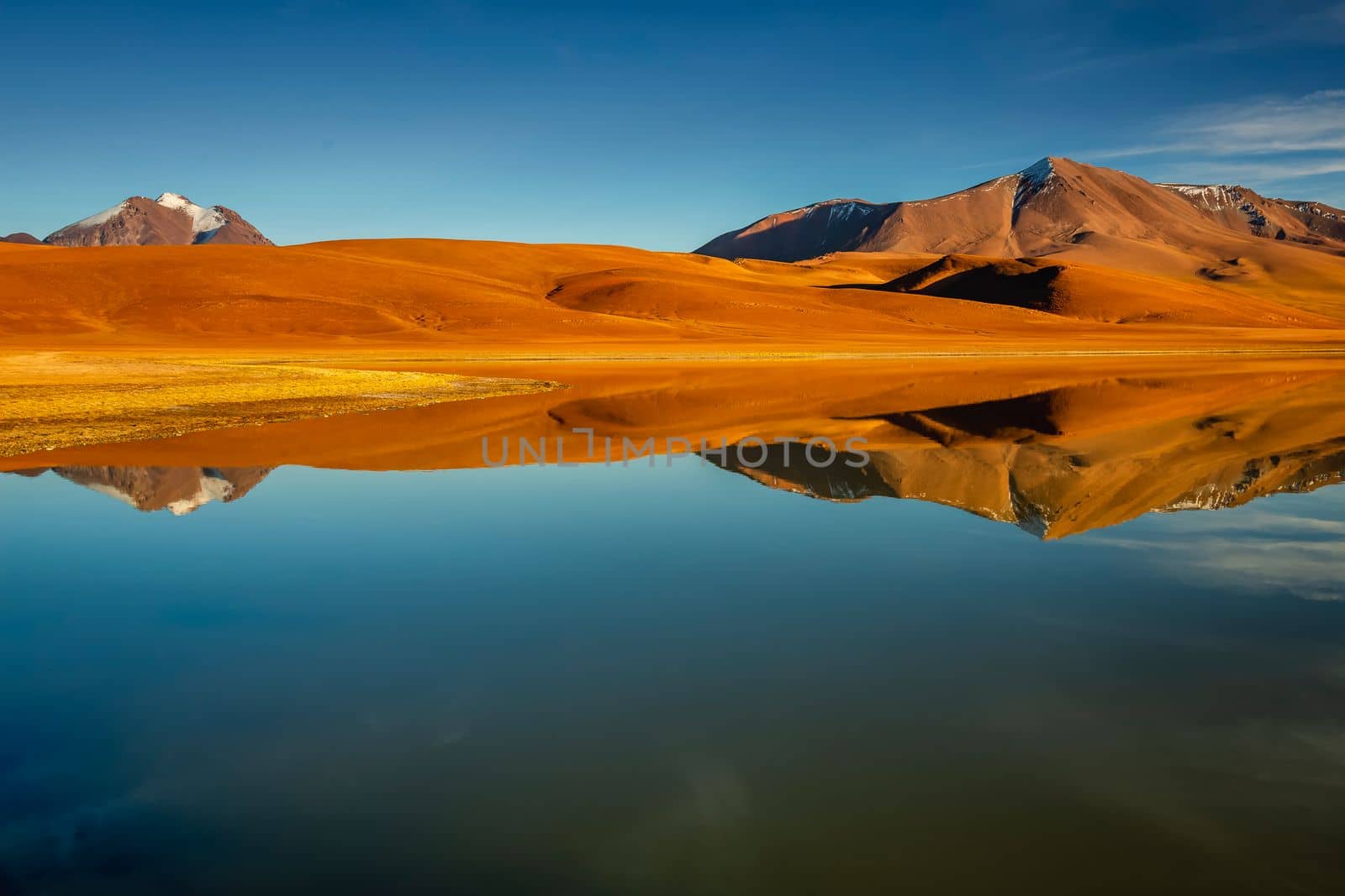 Salt lake Lejia reflection and idyllic volcanic landscape at Sunset, Atacama desert, Chile