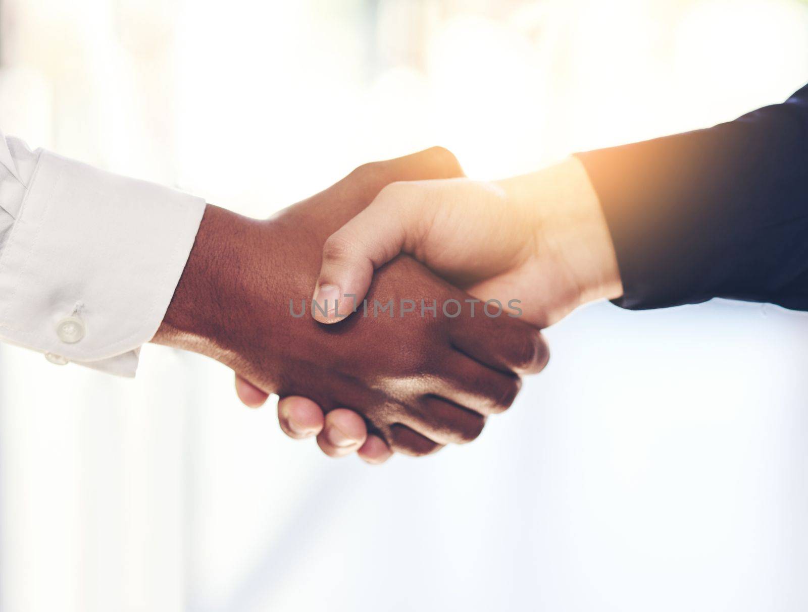 The start of a new partnership. Closeup shot of two unidentifiable businesspeople shaking hands in an office. by YuriArcurs