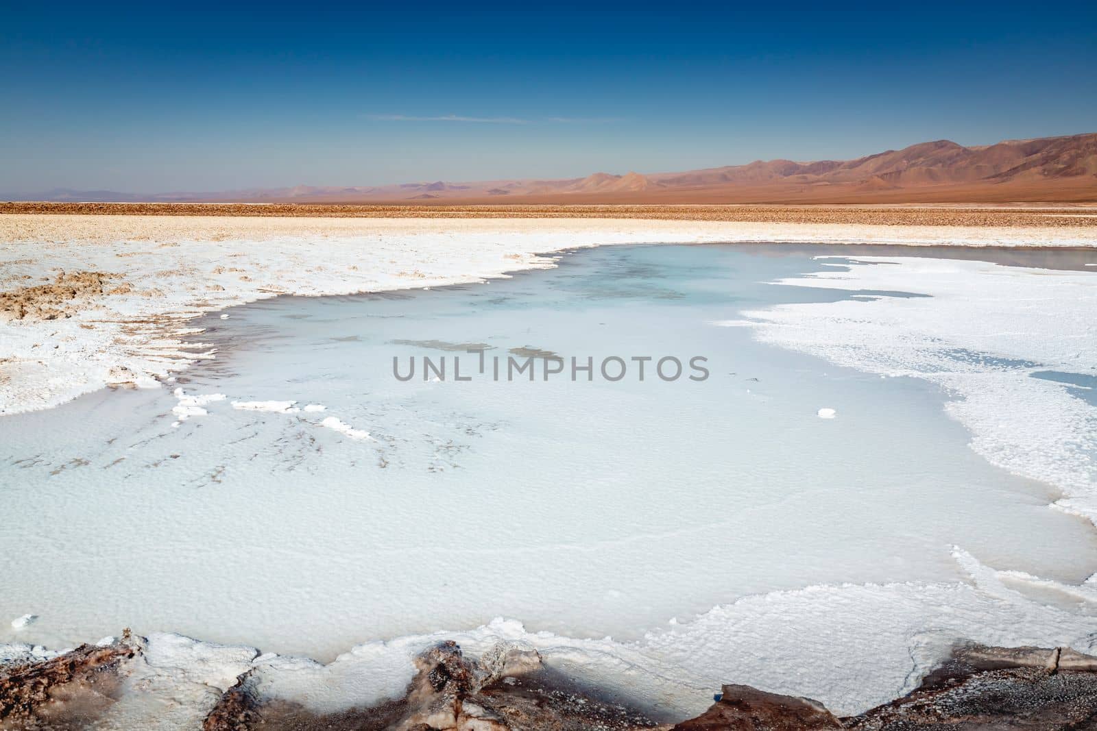 Salt lake reflection and idyllic volcanic landscape at sunrise, Atacama desert, Chile border with Bolivia
