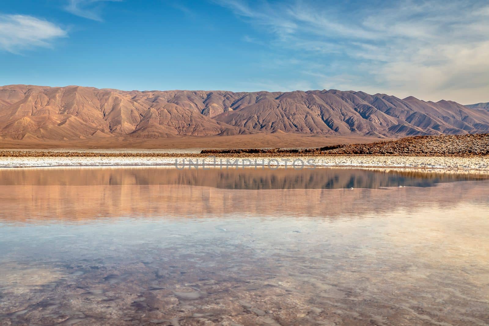 Salt lake reflection and idyllic volcanic landscape at sunrise, Atacama desert, Chile border with Bolivia