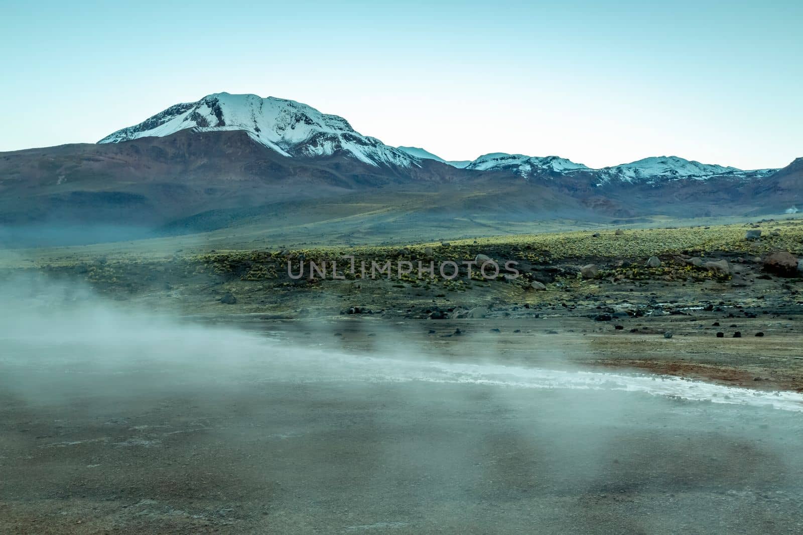 Geysers El Tatio with river and Peaceful dramatic volcanic landscape at sunrise, Atacama Desert, Chile