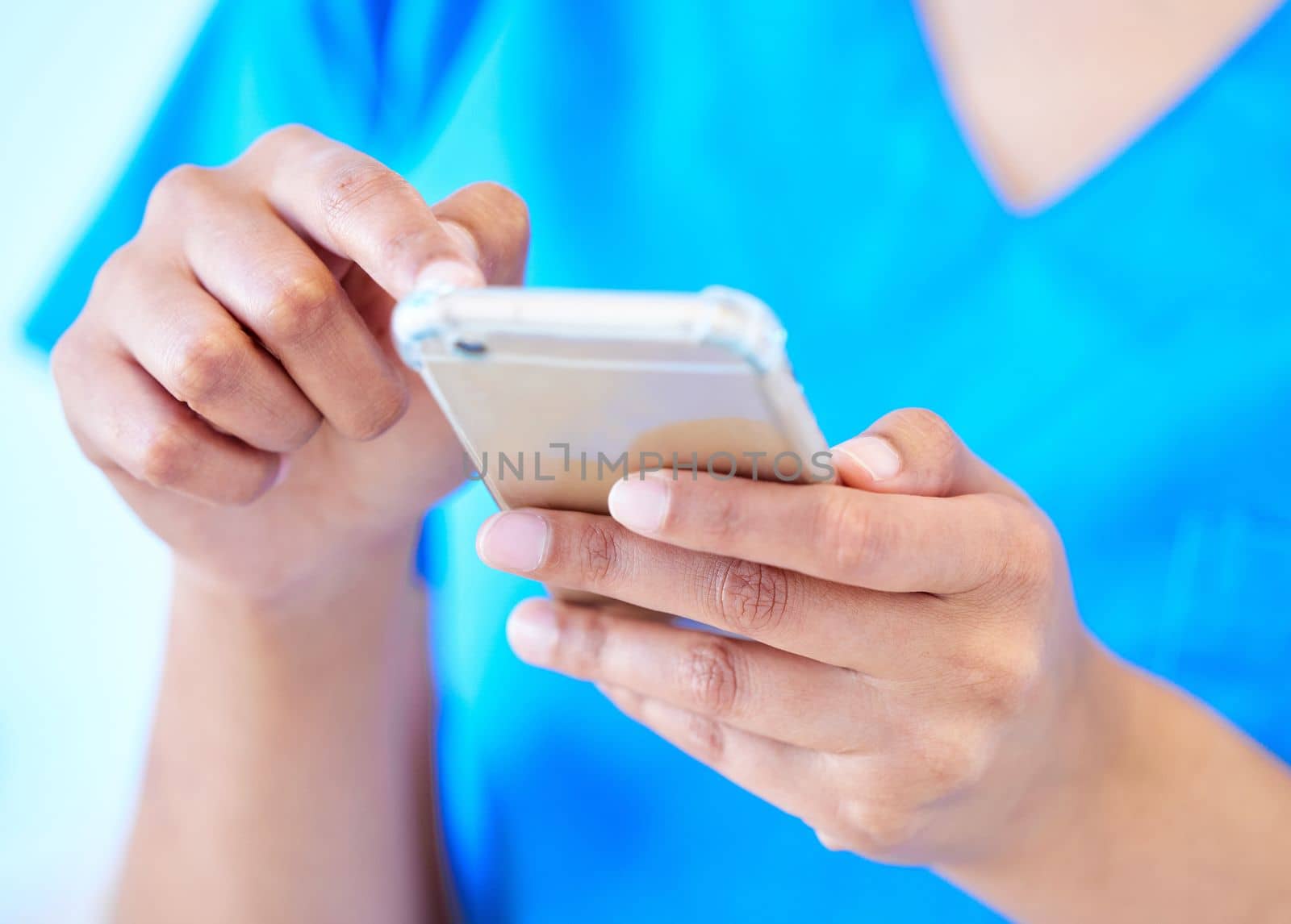 Those fingers move fast. a female dental assistant using her smartphone to send a text. by YuriArcurs