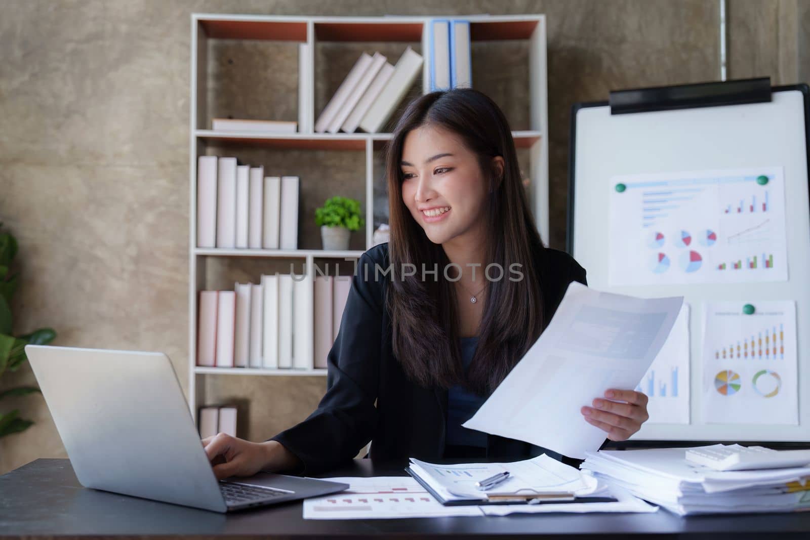 Beautiful Business woman working at home office and analyze financial report document. Accounting and Finance concept by itchaznong