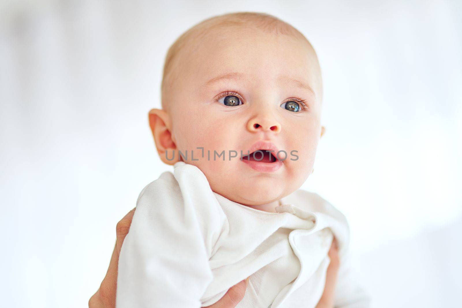 The world looks amazing from up here. a baby boy being held by his parent at home