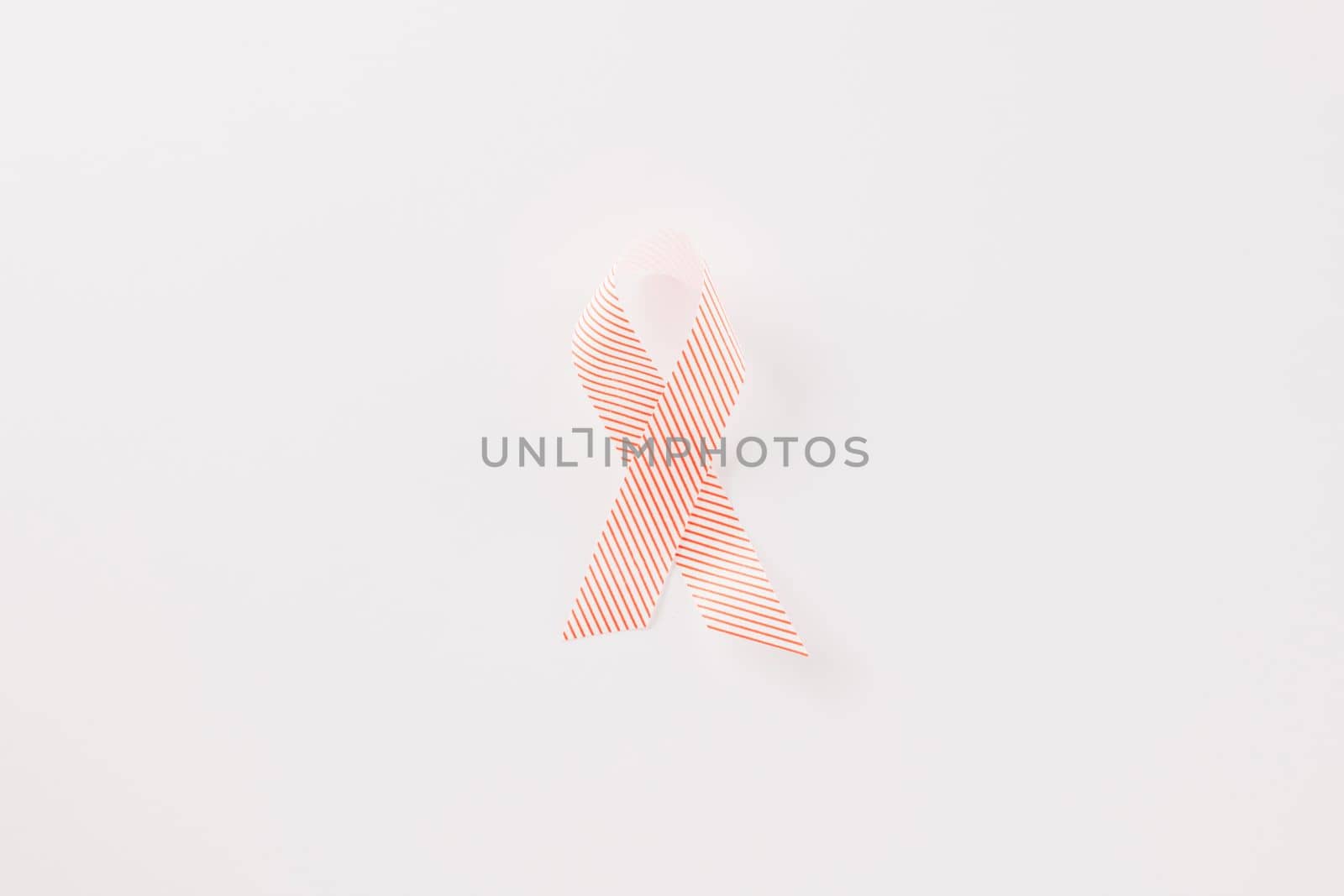 Close up pink awareness ribbon of International World Cancer Day campaign isolated on white background with copy space, concept of medical and health care support, 4 February