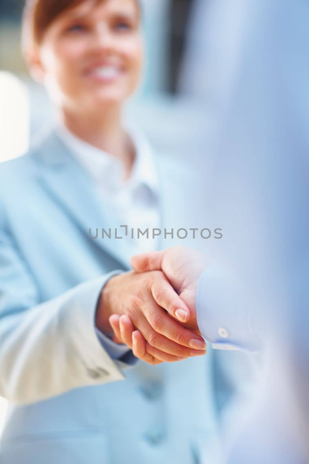 Youve got yourself a deal. two people shaking hands in a corporate environment