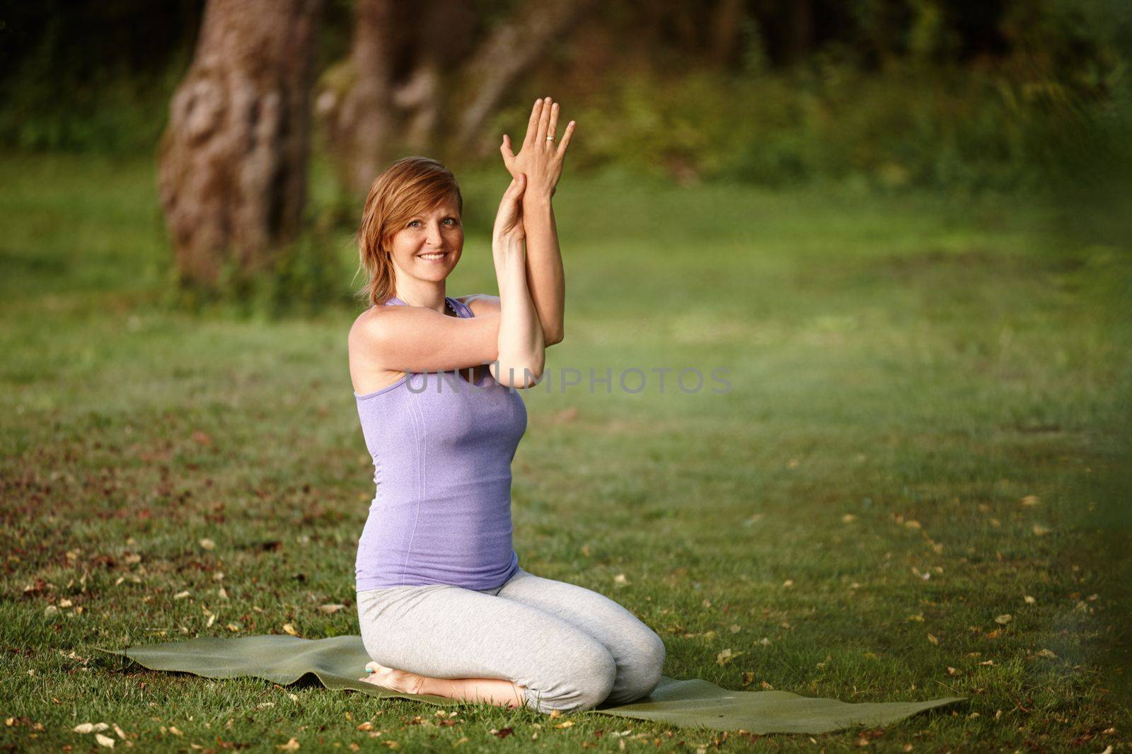 Yoga at the park. Portrait of an attractive woman doing yoga at the park. by YuriArcurs