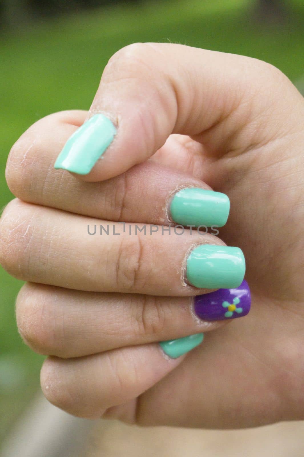 Womans hand with nails painted in green color by GemaIbarra