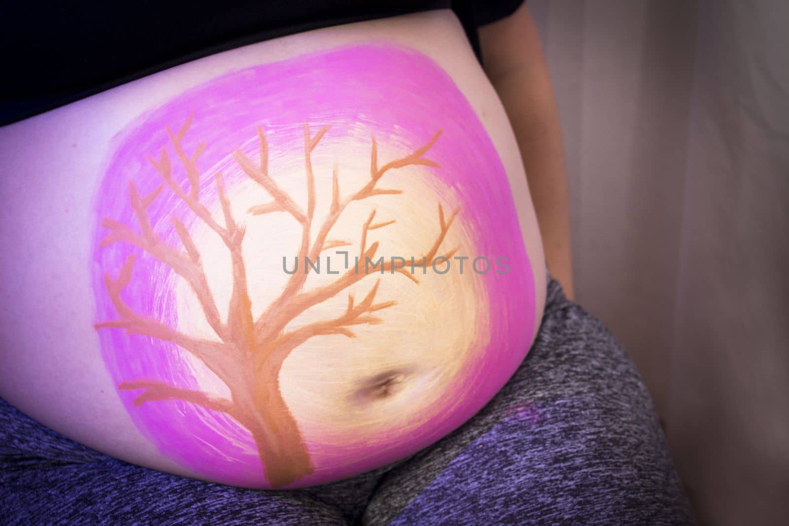 Girl drawing on belly of pregnant woman. No copy space