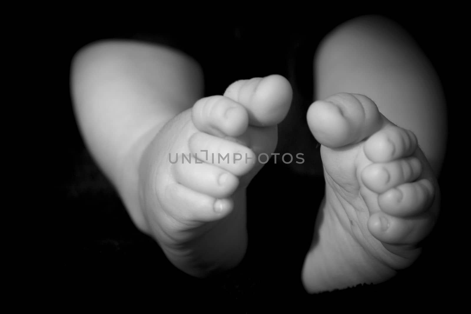 Baby feet on black background by GemaIbarra