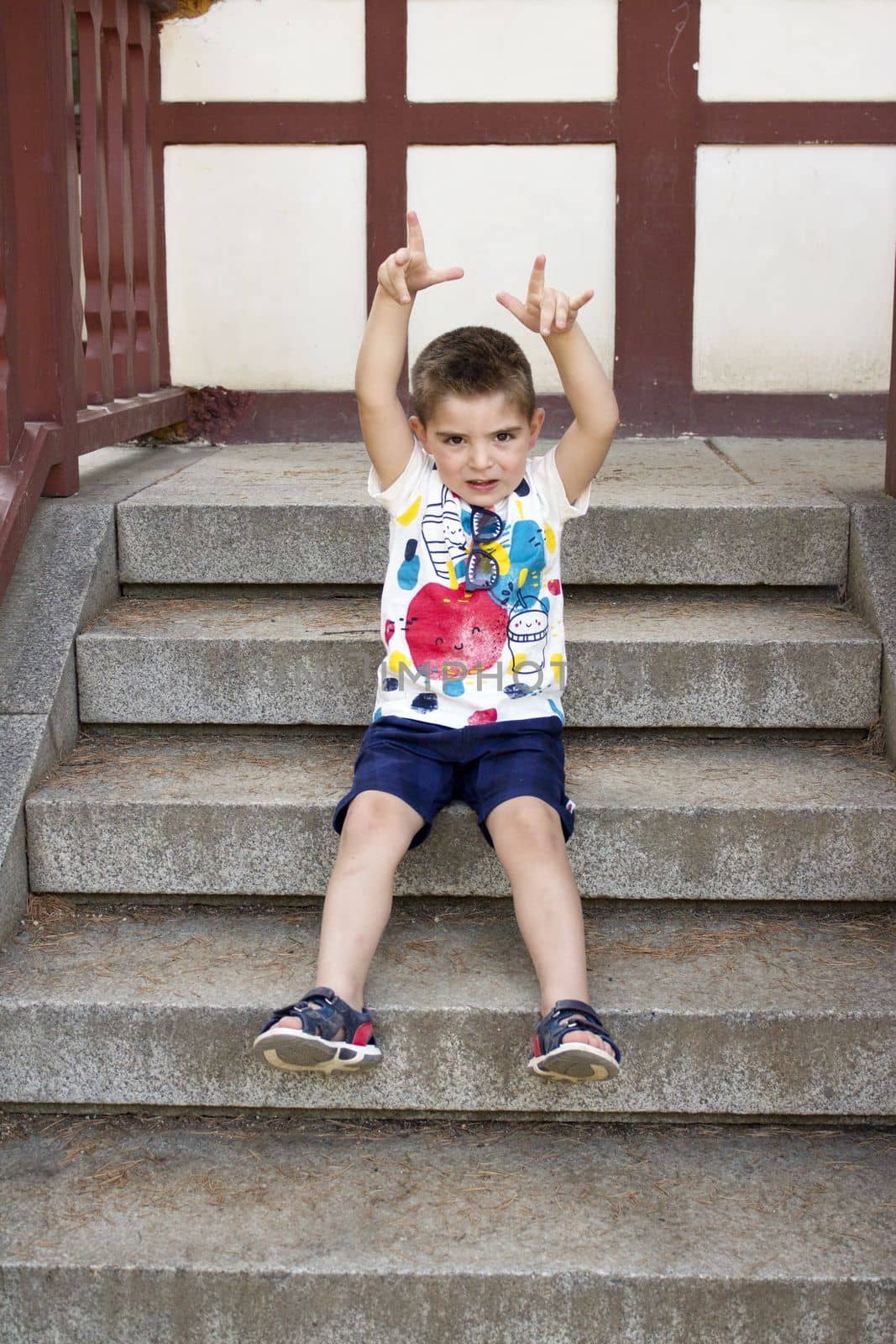 Four year old boy sitting gesturing. Alone