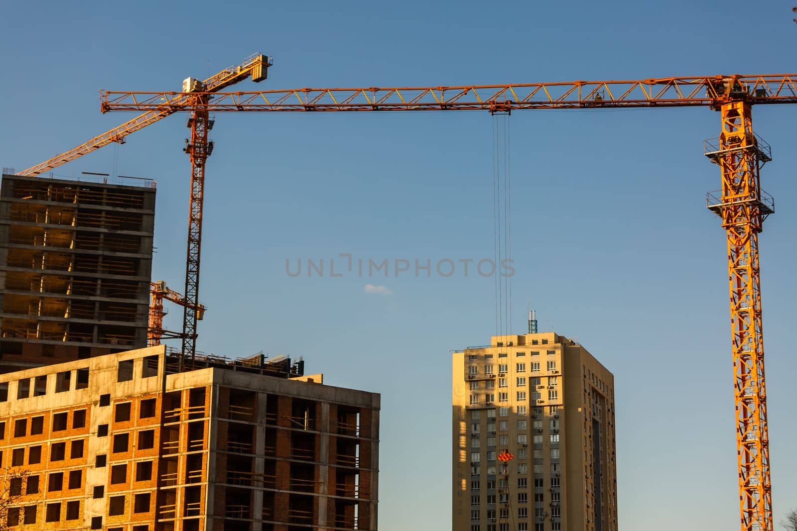 Crane. Construction crane. Building crane on the background of two buildings by Andelov13