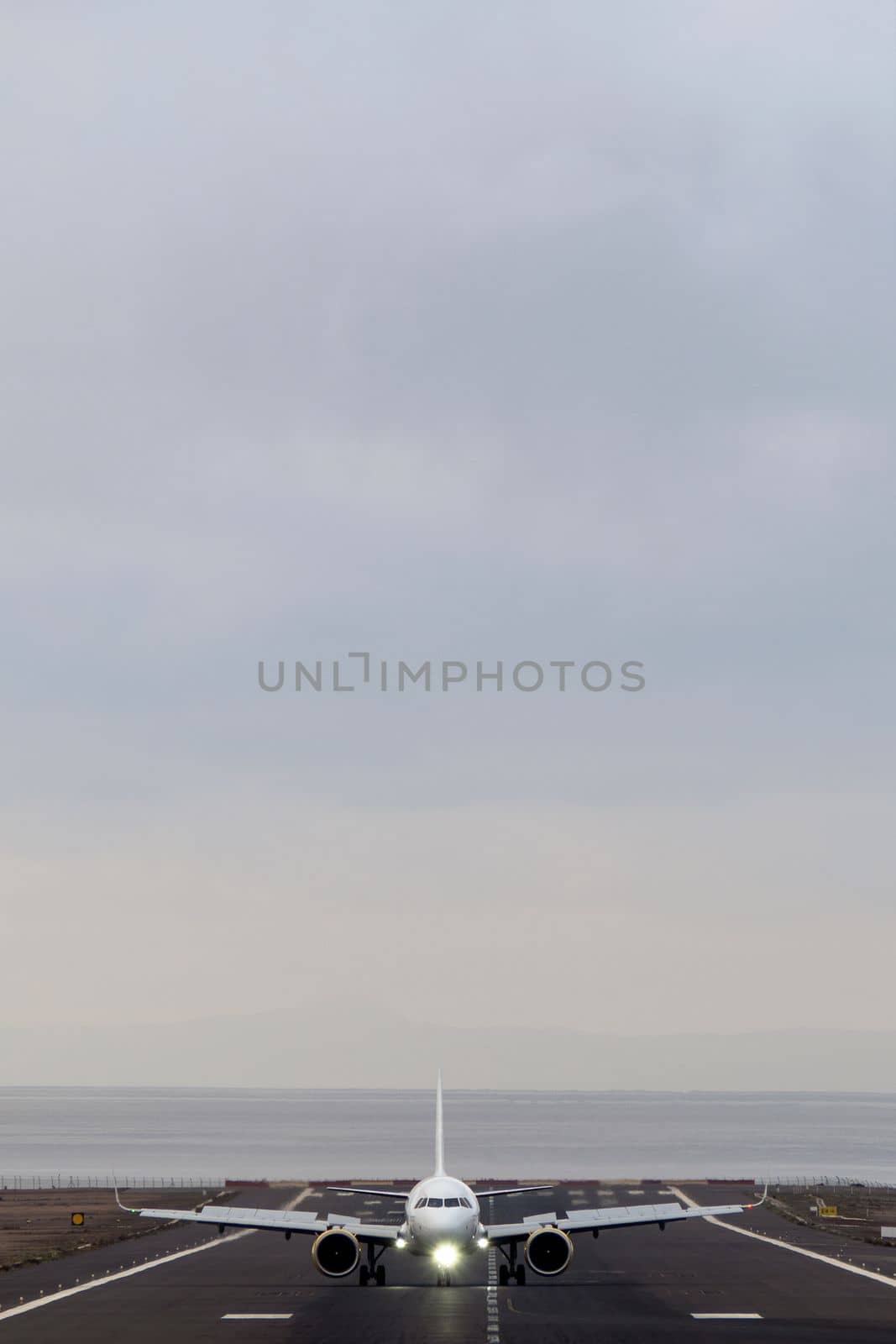 Frontal vertical shot of airplane takes off on a foggy day against the background of a gray sky