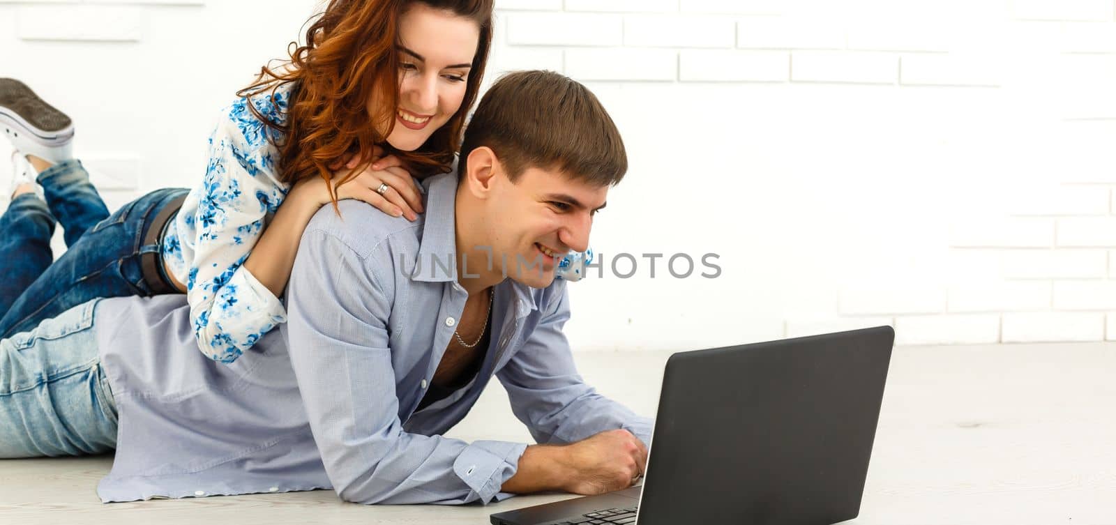 Couple buying online together with a laptop on a desktop at home by Andelov13