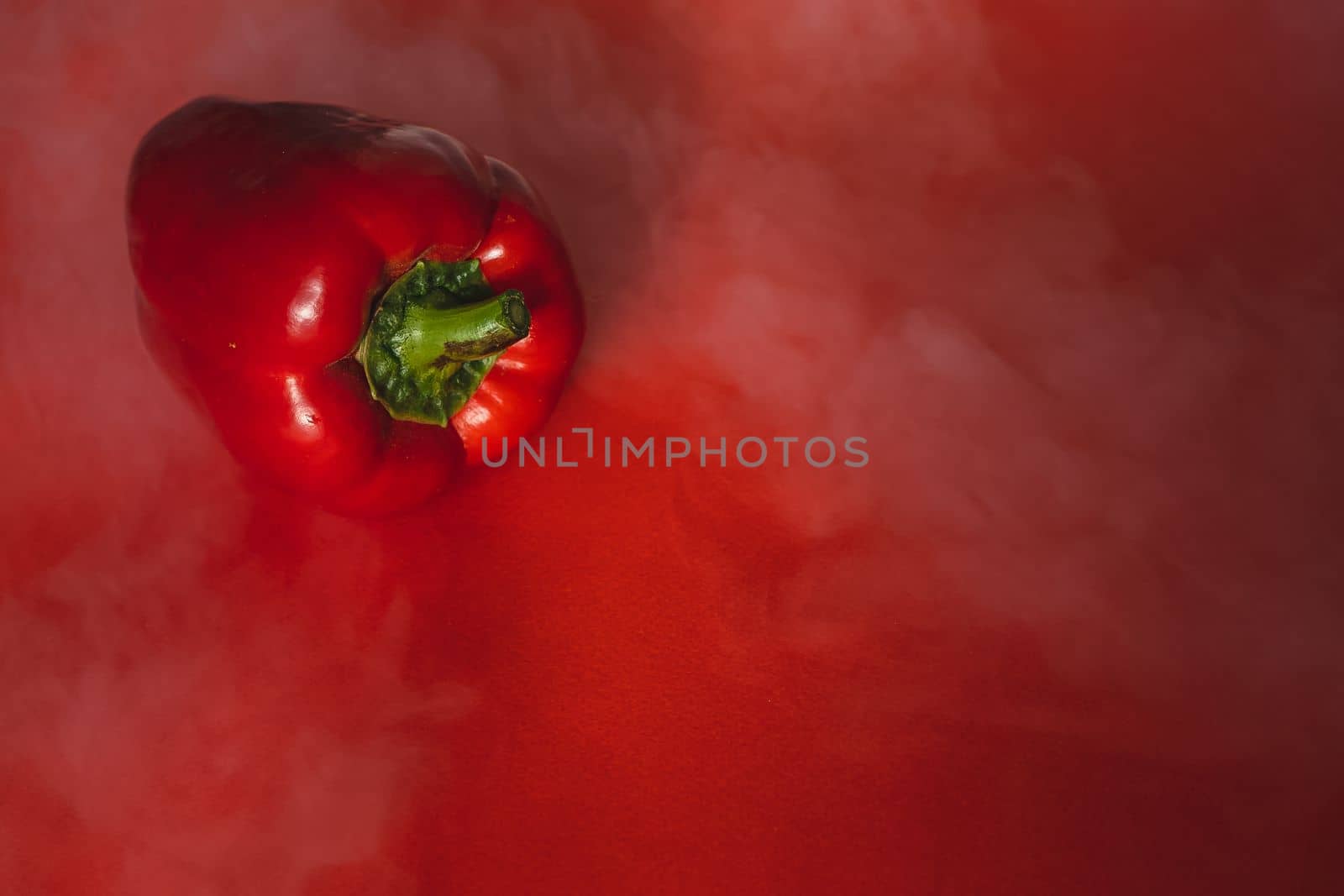 SWEET, fresh RED PEPPER ON RED BACKGROUND With smoke around, pepper. photo for the menu, proper nutrition. fresh vegetables.