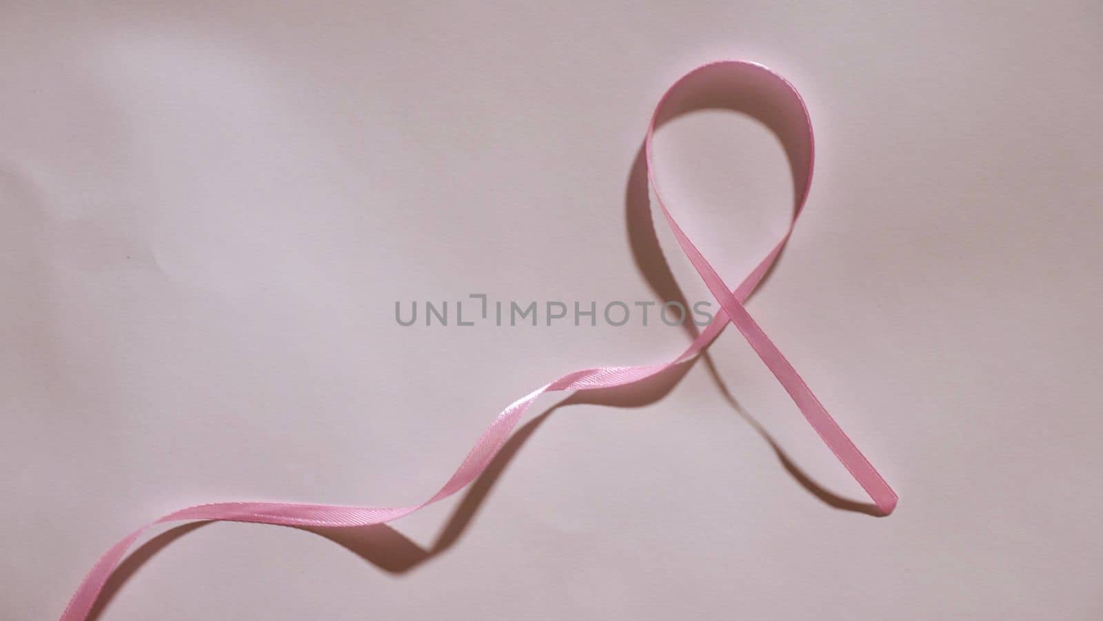 Breast Cancer disease symbol with pink ribbon on white background close-up on world Cancer Awareness Day 4 February
