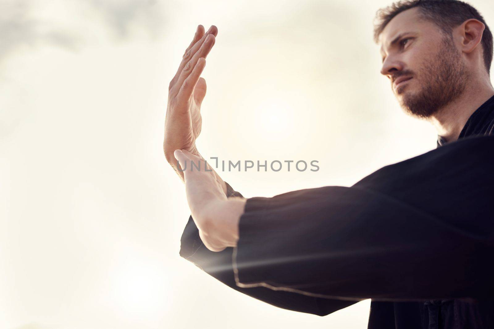 Karate, tai chi wellness or man on beach, sea or ocean for zen, fitness training or sports health in sunset lens flare. Focus, mindset or athlete for chakra exercise, peace or defense workout outdoor.