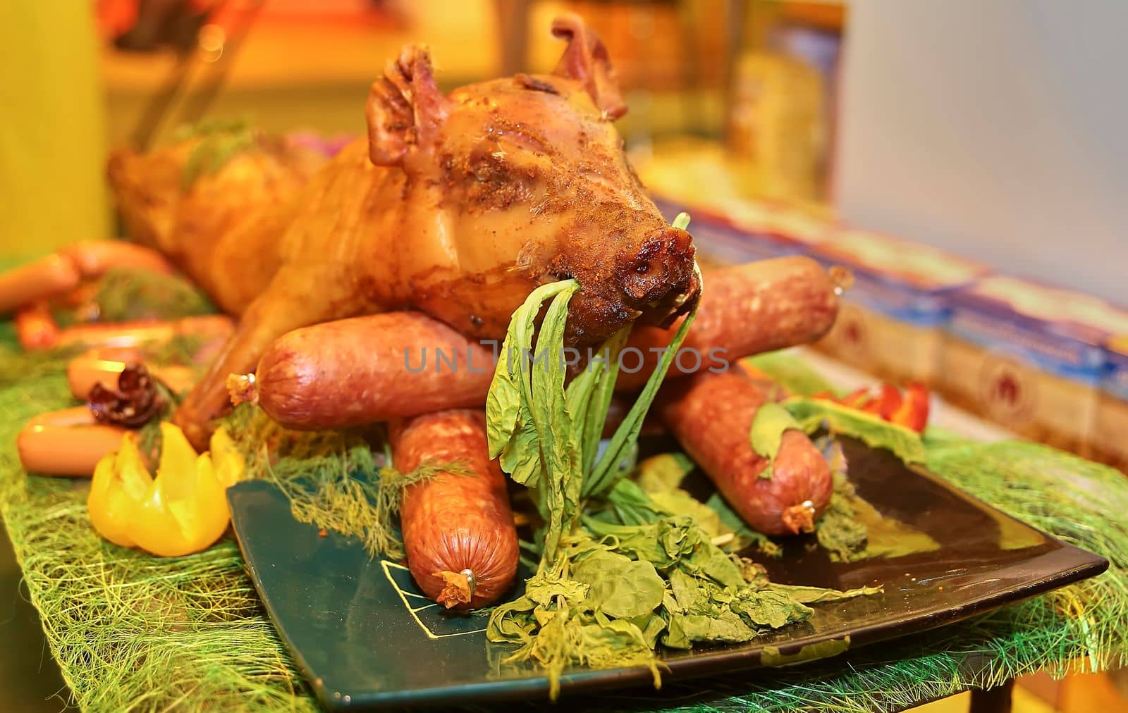 Grilled whole pig ready to serve. Sausage and a young pig on a platter.