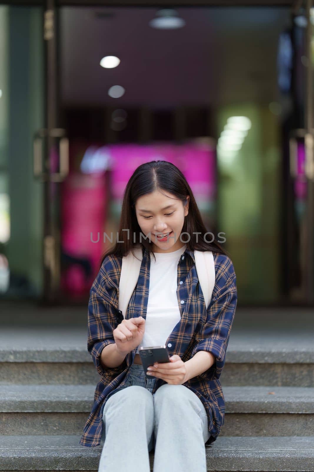 Young Beautiful woman using phone and celebrate while in victory position by itchaznong