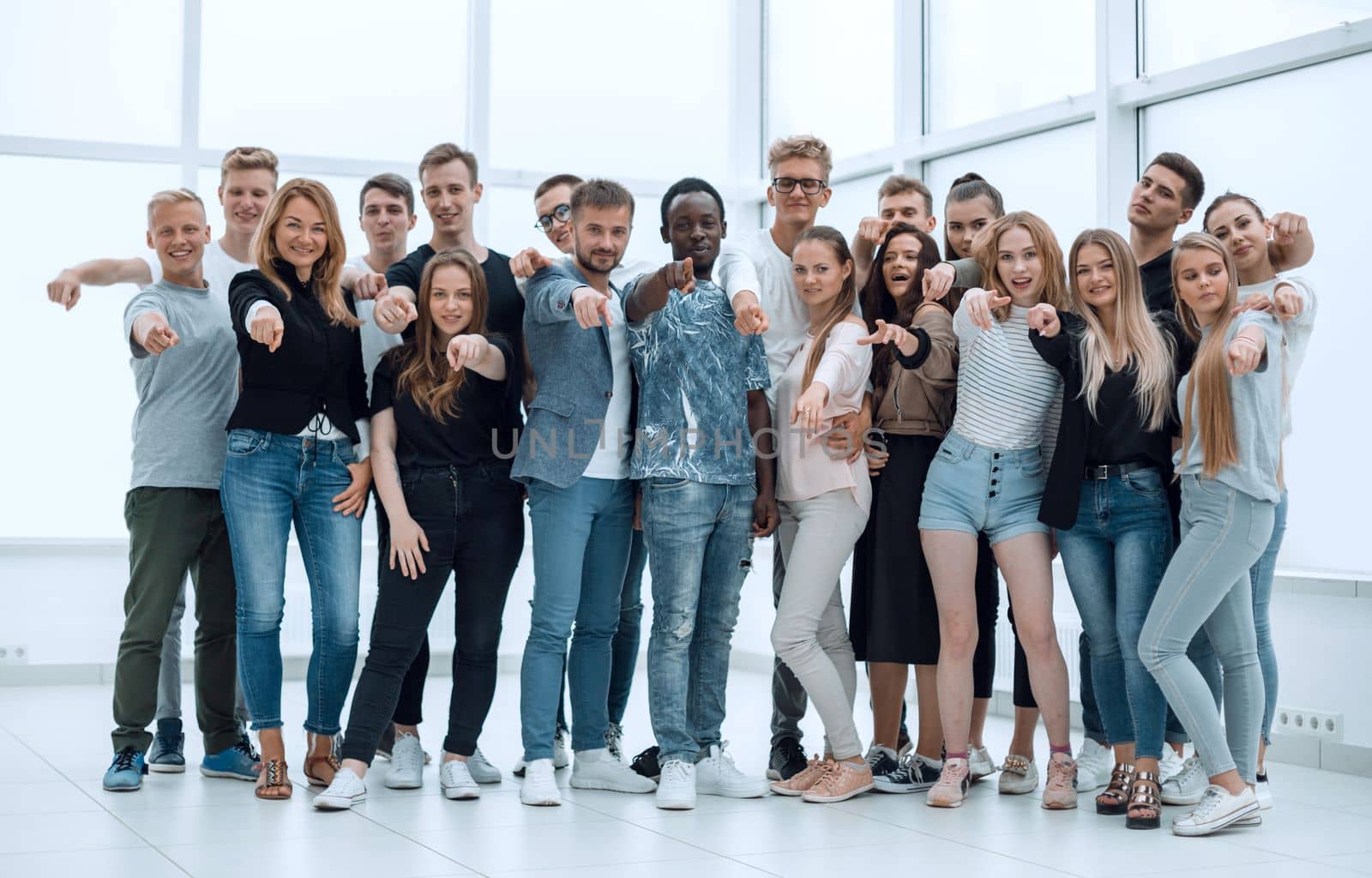 group of happy young men pointing at you. photo with copy space