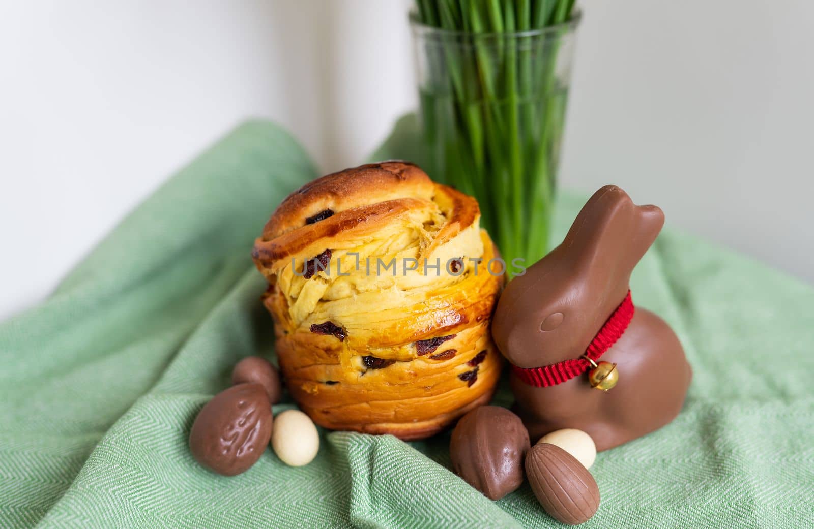 Homemade Easter traditional pastries lie on a green napkin with a bouquet of flowers, a rabbit, chocolate eggs. Easter baking and decoration