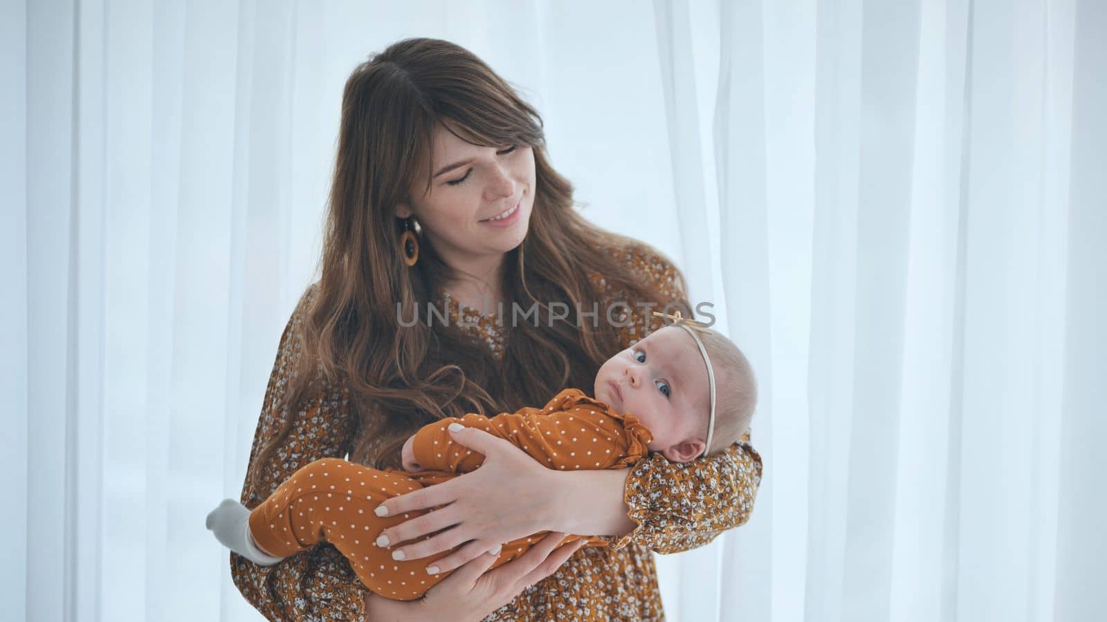 A loving mother and child at the window with curtains