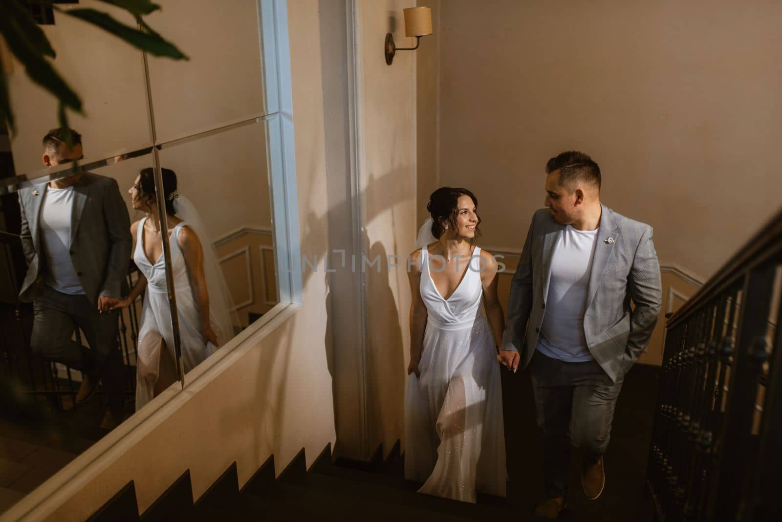 young couple the groom in a blue suit and the bride in a white dress on a walk