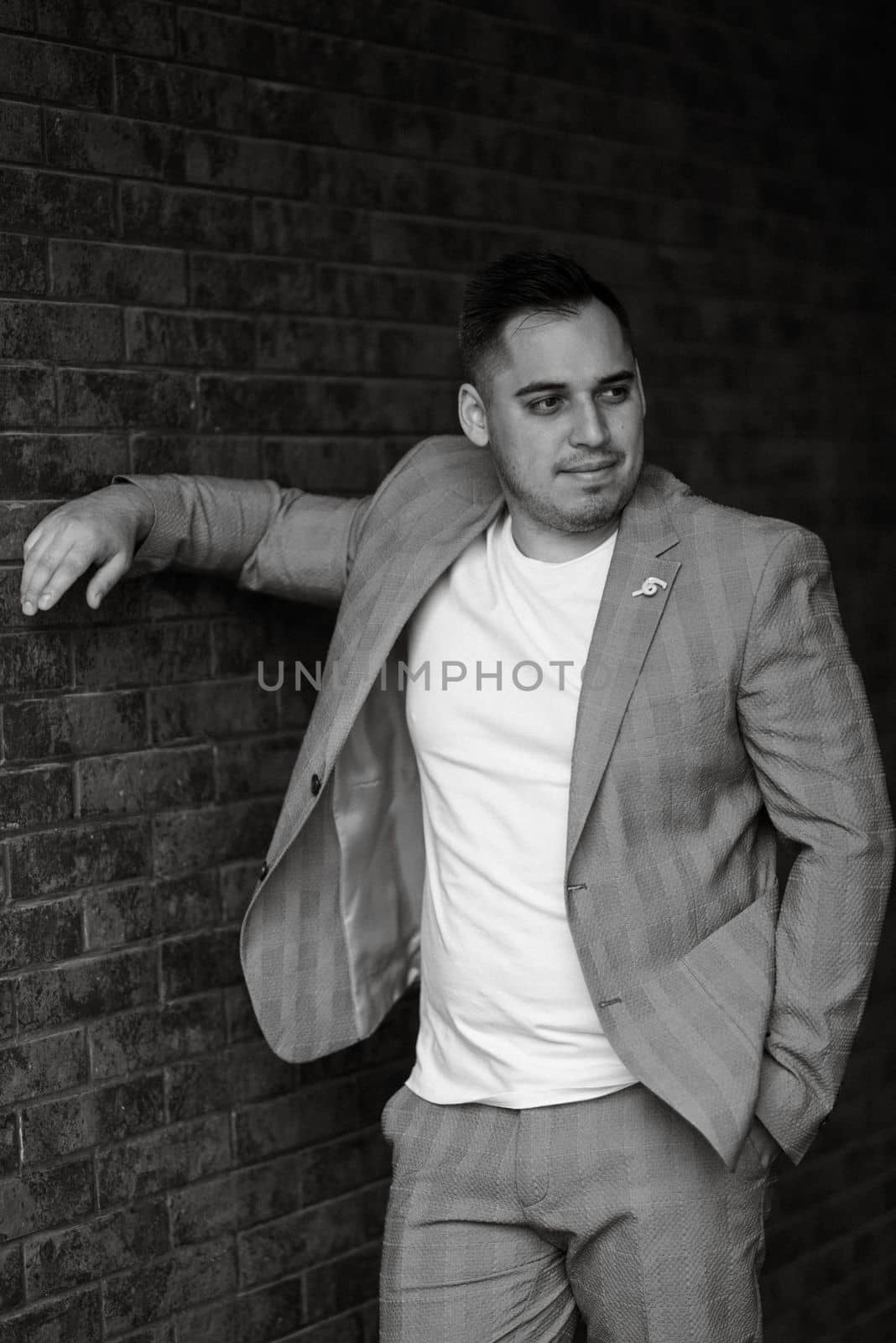 portrait of the groom in a light gray suit indoors