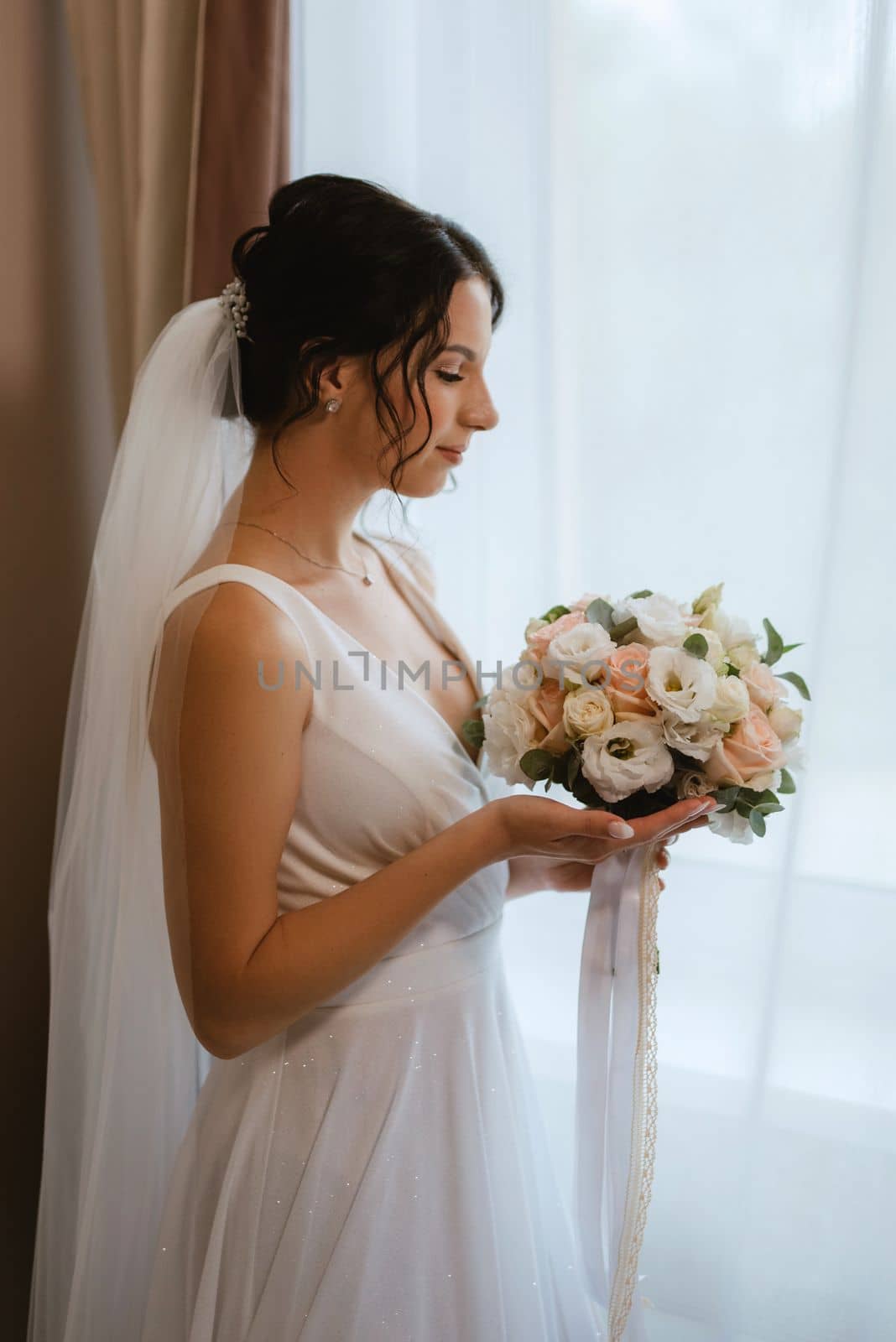 preparations for the bride with the dressing of the wedding dress in the studio