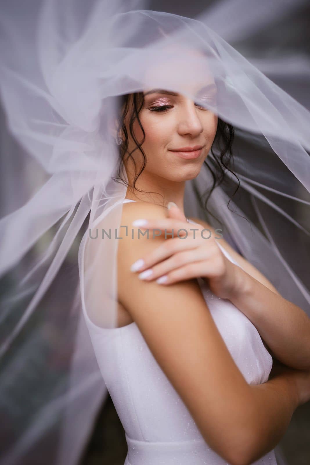 preparations for the bride with the dressing of the wedding dress in the studio