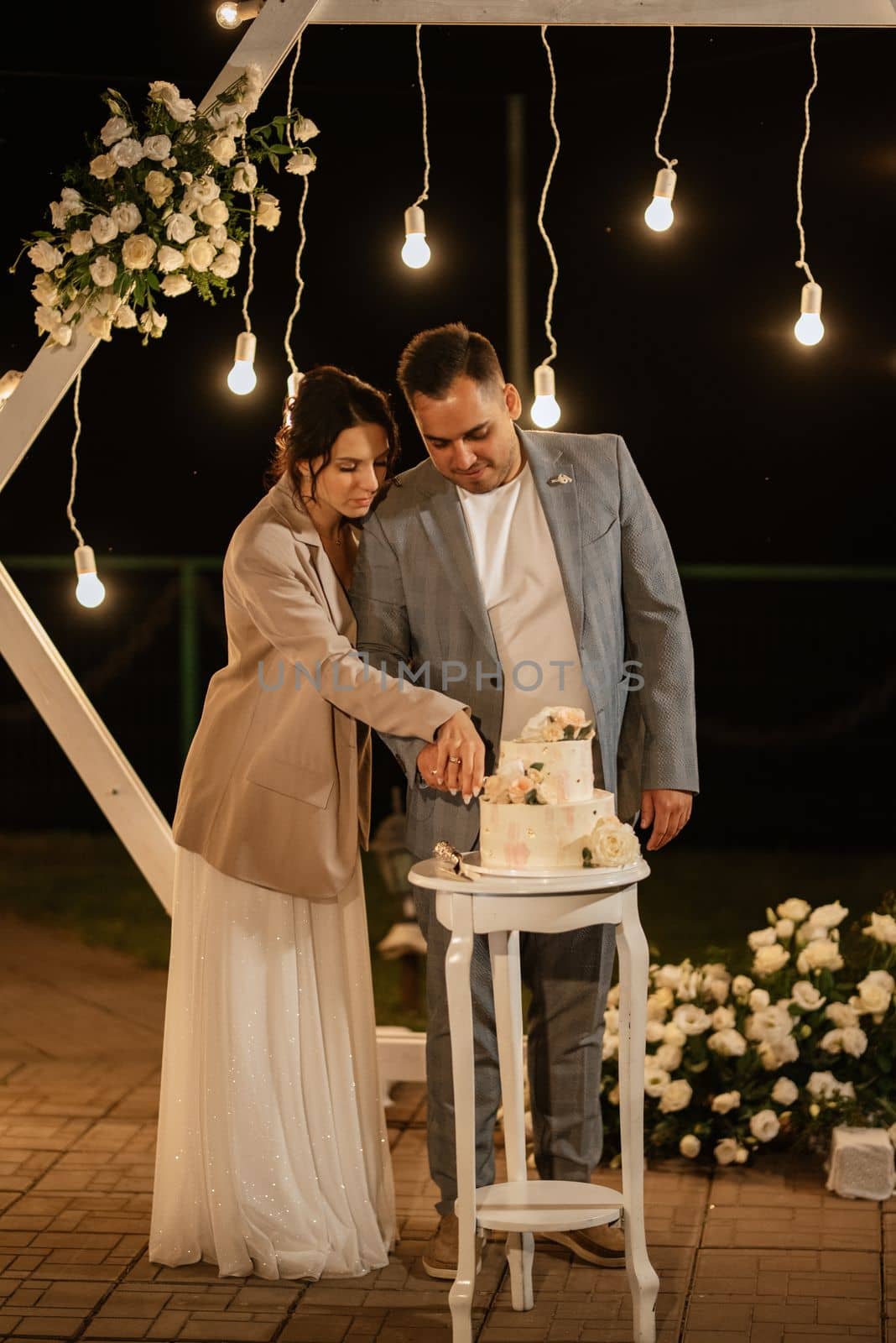 newlyweds happily cut, laugh and taste the wedding cake