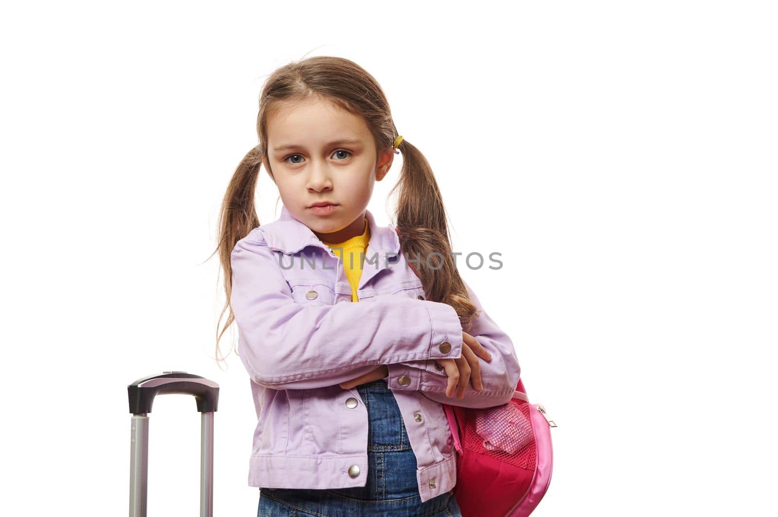 Pretty baby girl , preschooler child with two ponytails, posing with backpack and suitcase over white background. Travel by artgf