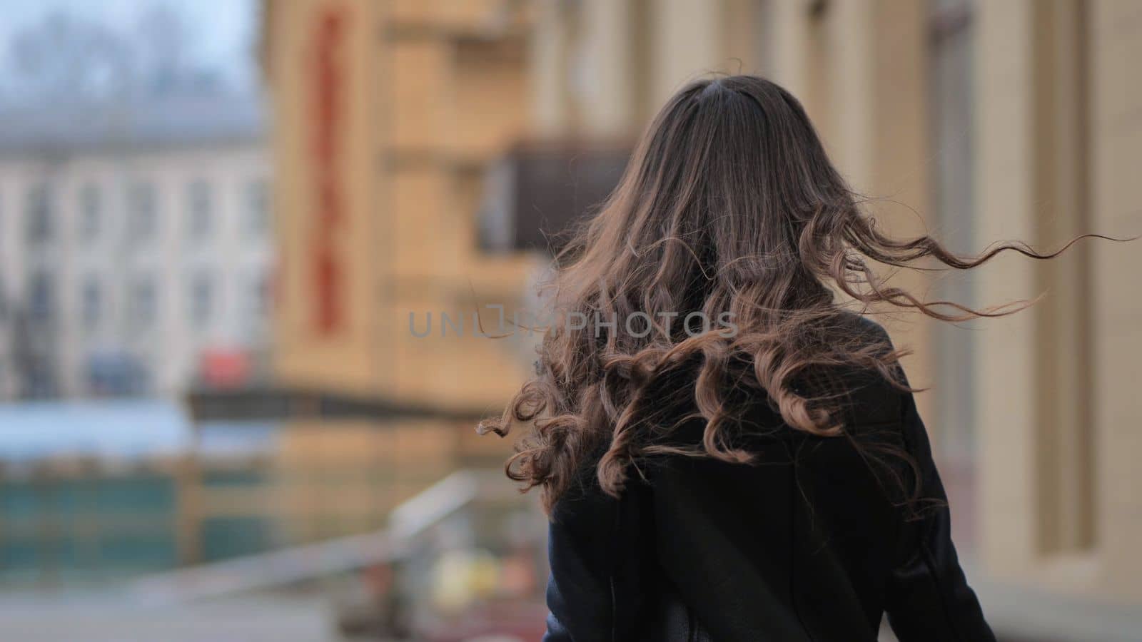 Portrait of a posing happy girl in the city in early spring
