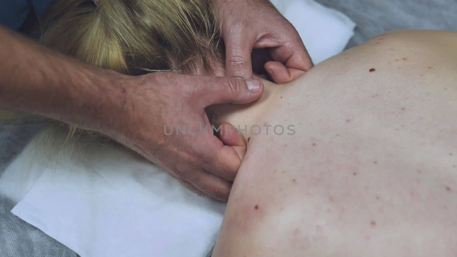 Men's hands massage the neck for a young girl